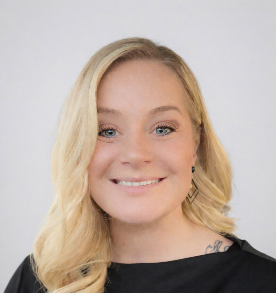 Head-and-shoulders portrait of smiling woman with blond hair and earrings against light background