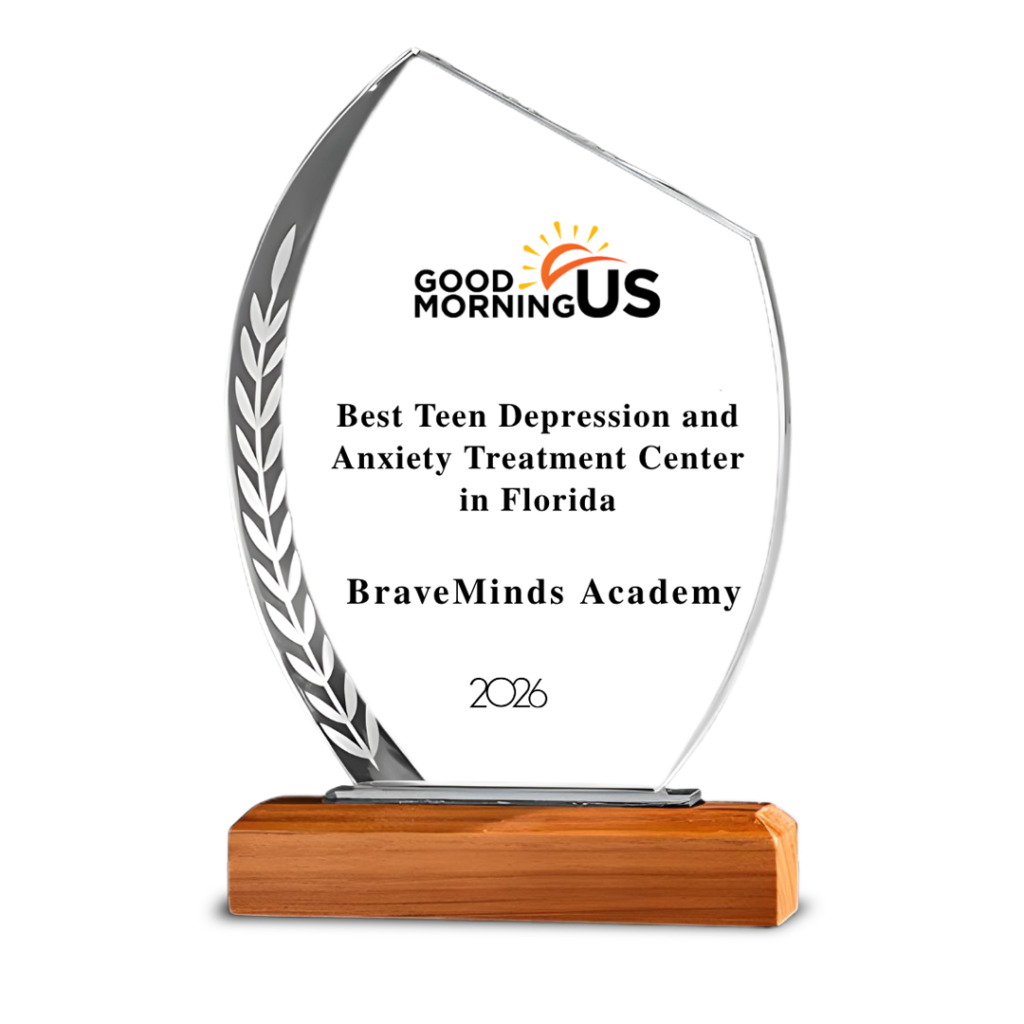 Glass trophy with leaf motif, inscription for BraveMinds Academy, 2026, on wooden base.